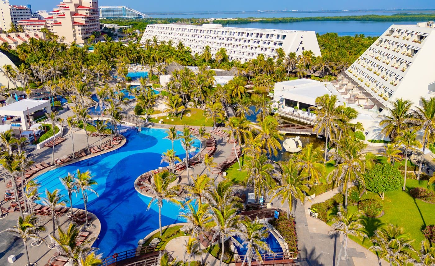 Vista aérea del Grand Oasis Cancún con sus torres piramidales, albercas y la Laguna Nichupté al fondo